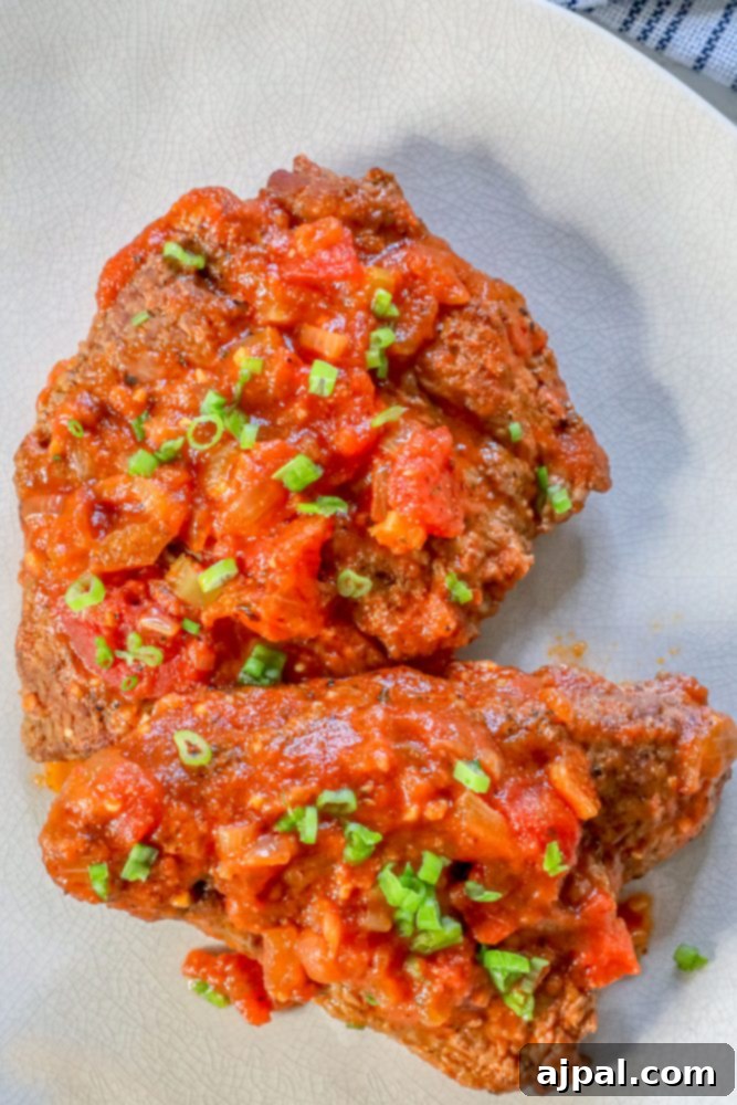 Homemade Swiss Steak: A Step-by-Step Guide 3 steak with outer coating and tomato sauce on top