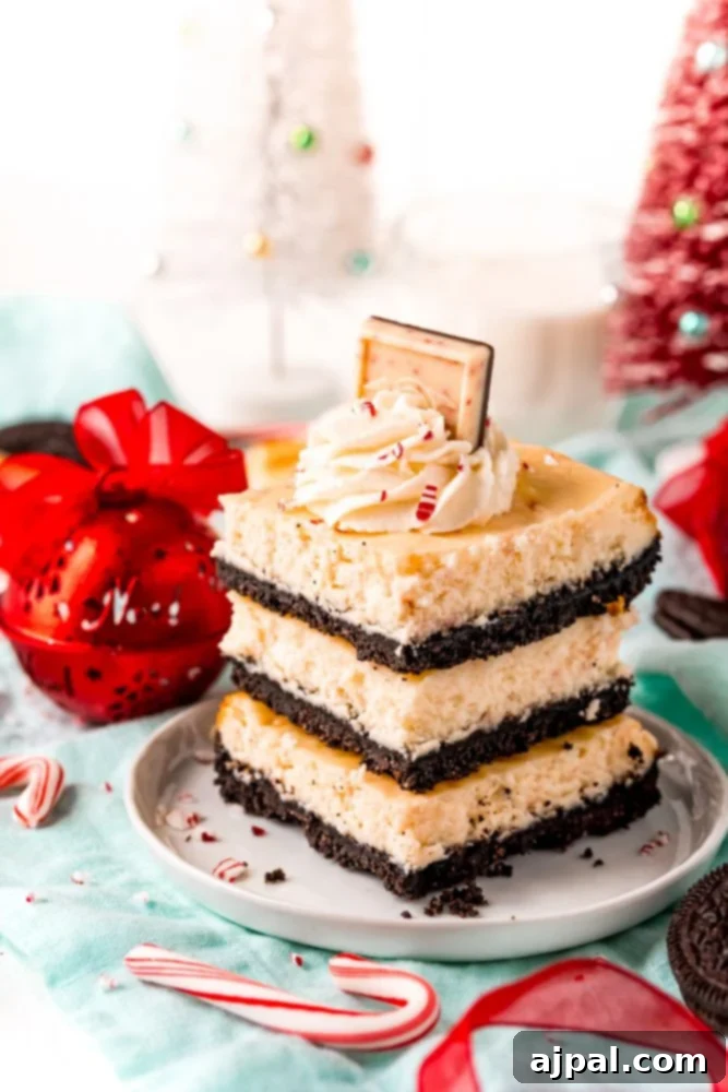 A festive stack of peppermint cheesecake bars on a plate, garnished with candy canes.