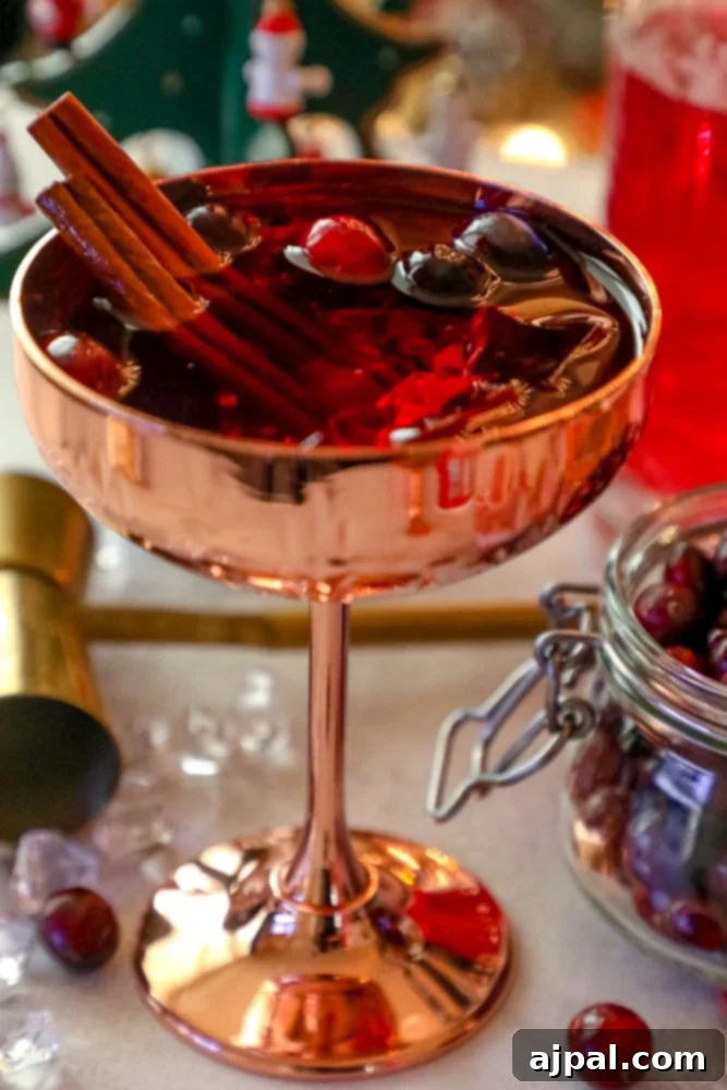 A flavorful Christmas sangria recipe featuring cranberries and cinnamon served in a copper cup.