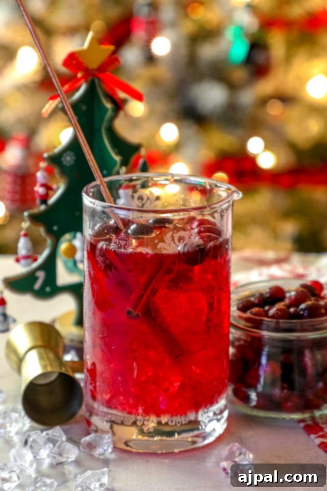 A glass of Easy Cranberry Sangria with Christmas decorations.