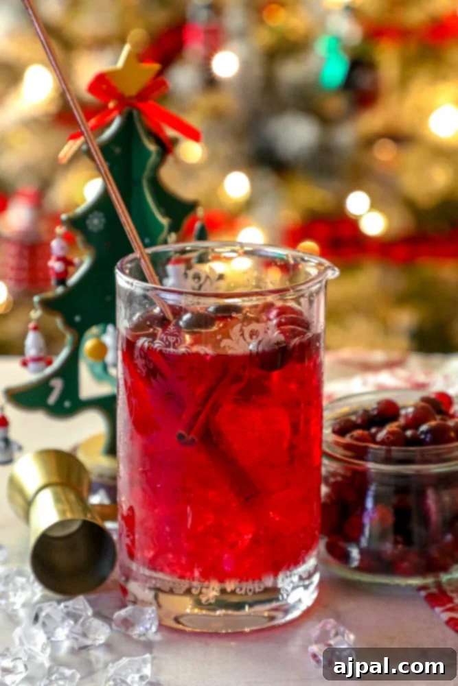 A glass of Easy Cranberry Sangria with Christmas decorations.