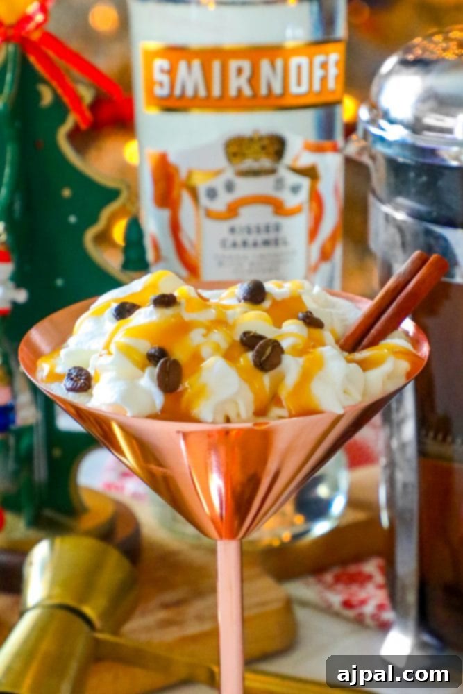 A captivating brass martini glass, adorned with luscious whipped cream, aromatic espresso beans, and a fragrant cinnamon stick, elegantly stands alongside a bottle of Smirnoff, capturing the essence of a perfect Caramel Espresso Martini. 