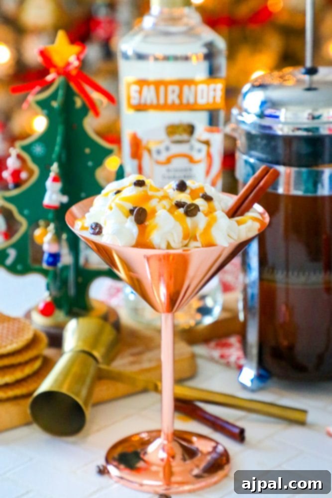 A glistening brass martini glass holds a tempting caramel espresso cocktail, elegantly garnished with a creamy topping and nestled beside a selection of delicate cookies, inviting a moment of pure indulgence.