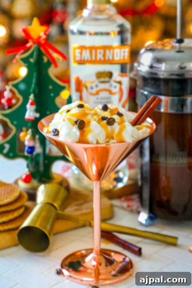 A glistening brass martini glass, artfully adorned with creamy whipped topping, a sprinkle of espresso beans, and a fragrant cinnamon stick, showcases the rich appeal of a Caramel Espresso Martini, a perfect blend of coffee and indulgence.