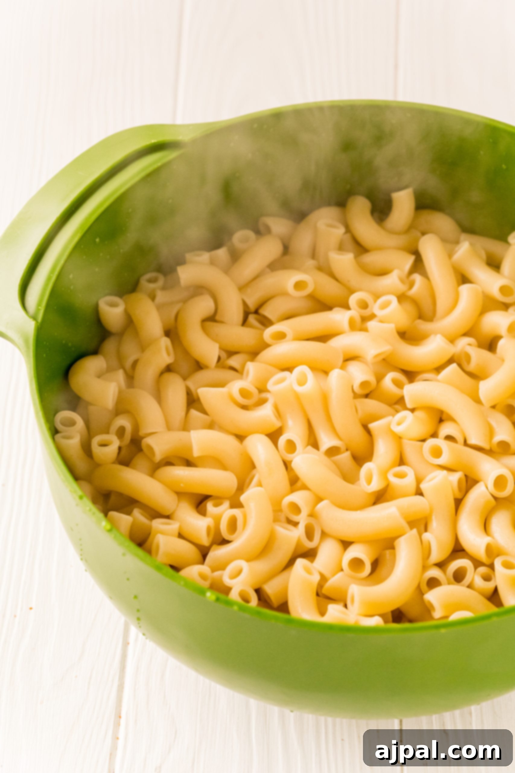 A green pan with macaroni in it, a recipe for The Best Easy Mac and Cheese with pub cheese.