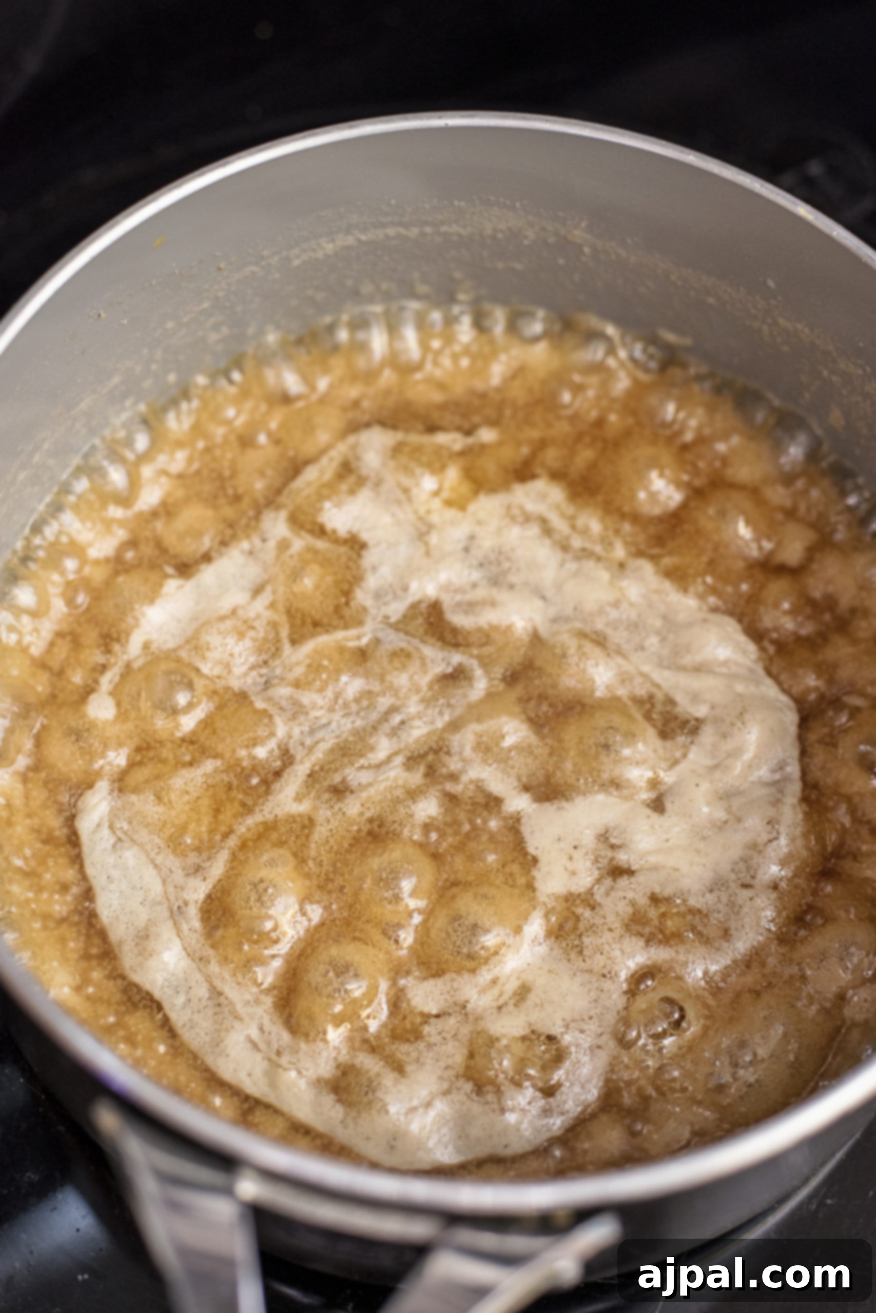 Decadent Caramel Apple Spice Cake Made Easy 8 A frying pan on a stovetop with ingredients simmering, preparing the delectable caramel sauce for the easy spice cake recipe.