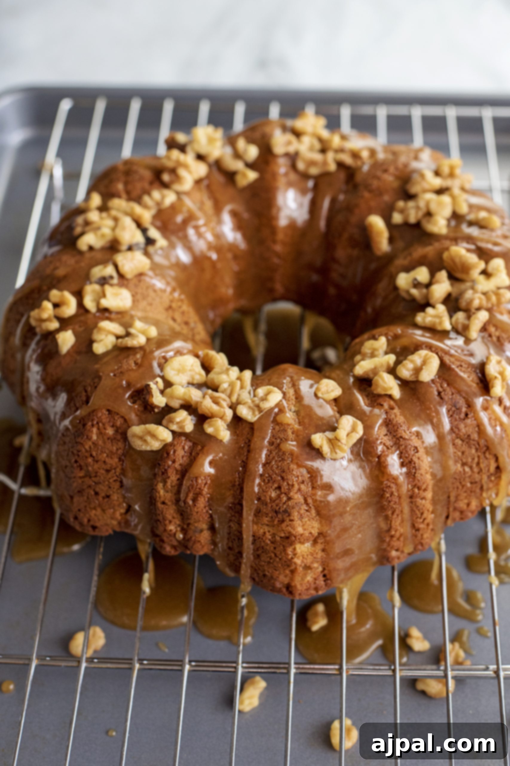An Apple Spice Bundt Cake perfectly cooled on a wire rack, its intricate design visible, ready for its final adornments.