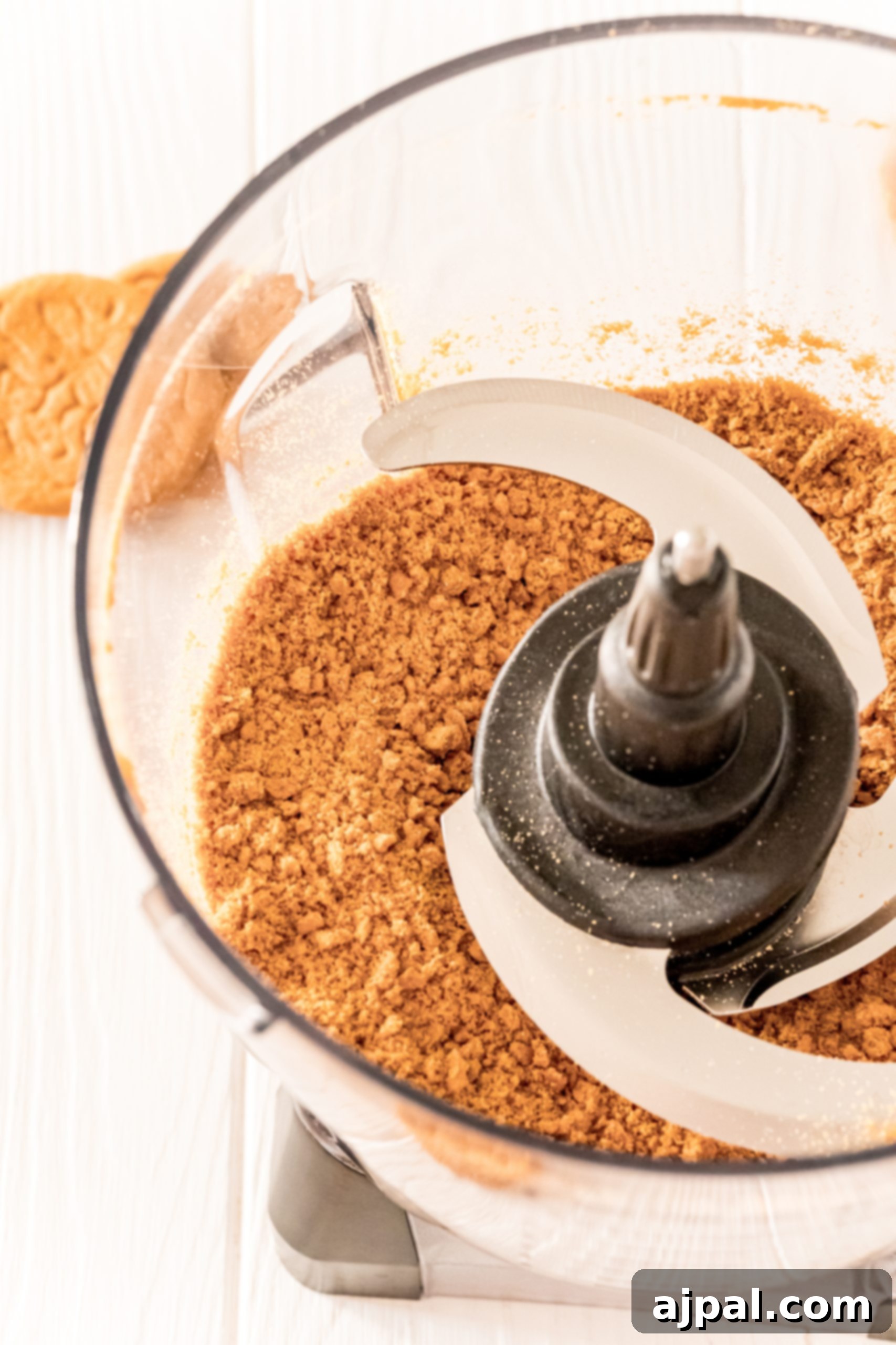 A food processor filled with gingersnap cookies and powdered sugar, a key step in making gingerbread truffles.