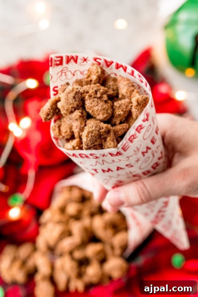 A person holding a cone full of delicious and easy candied nuts.