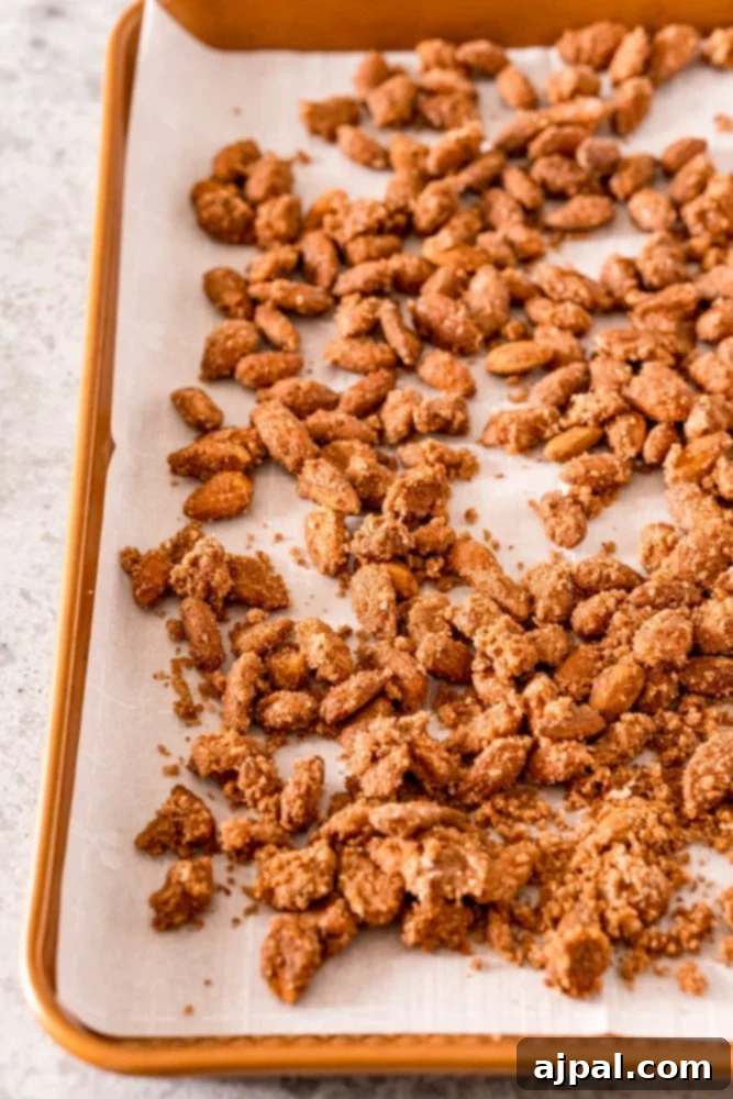 Picture of almonds and sugar on baking sheet with parchment paper