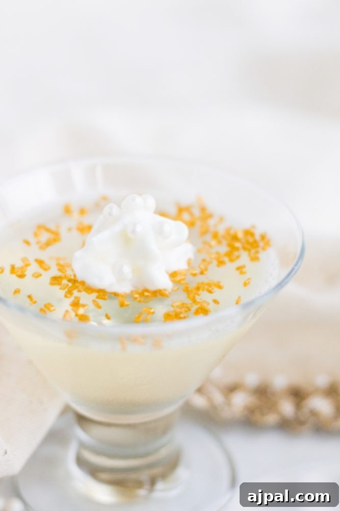 A pristine white jello shot, elegantly presented in a small glass, topped with a delicate swirl of whipped cream and a sprinkle of golden yellow sugar, symbolizing pure celebration.