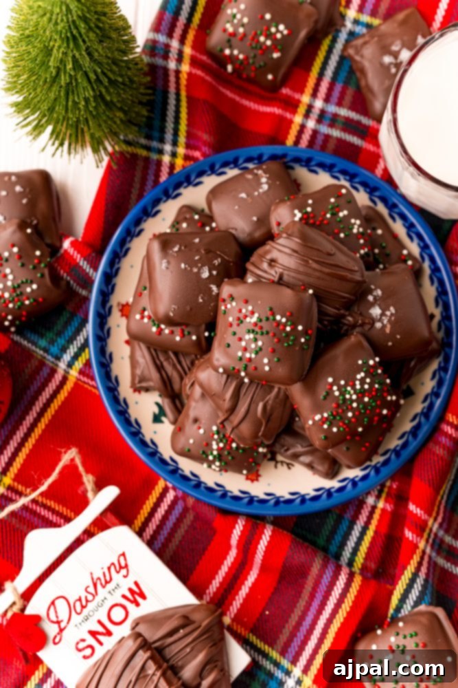 Decadent Millionaire Shortbread Bites Made Easy 3 A charming plate of chocolate-covered snowballs and shortcut Twix cookies, meticulously arranged on a cozy plaid tablecloth, ideal for holiday gatherings and festive treats.