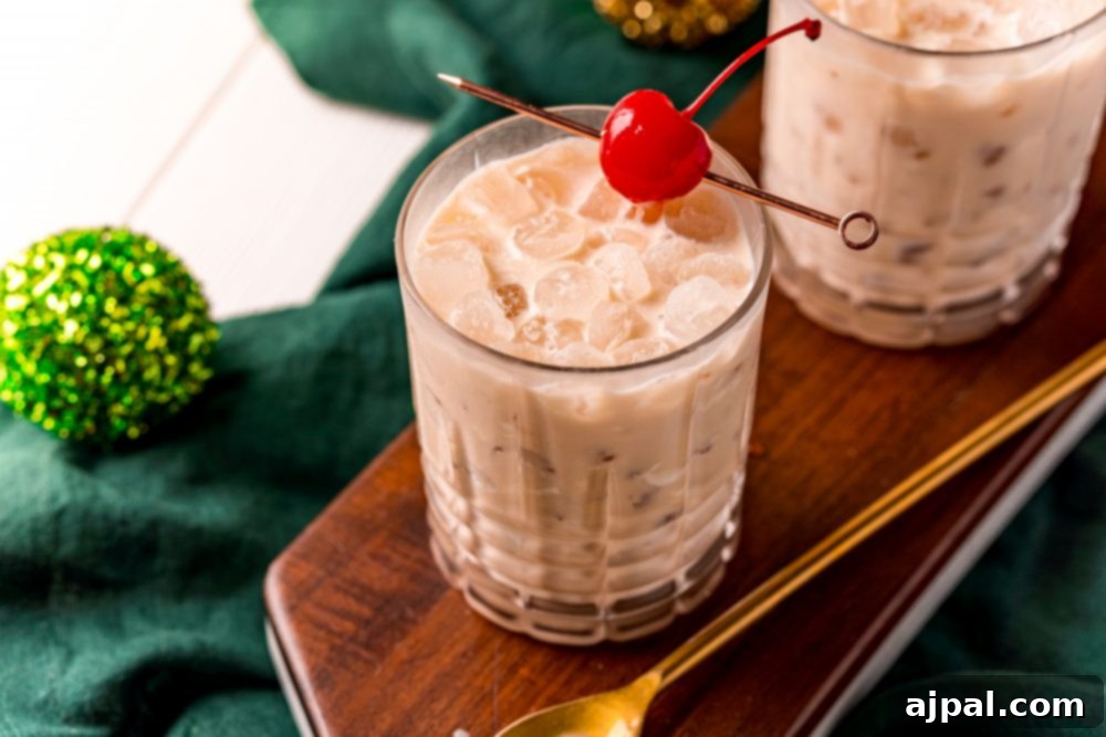 Two enticing glasses of Irish Cream White Russian cocktails, elegantly prepared with a cherry on a stick, showcasing their creamy texture and inviting appeal.