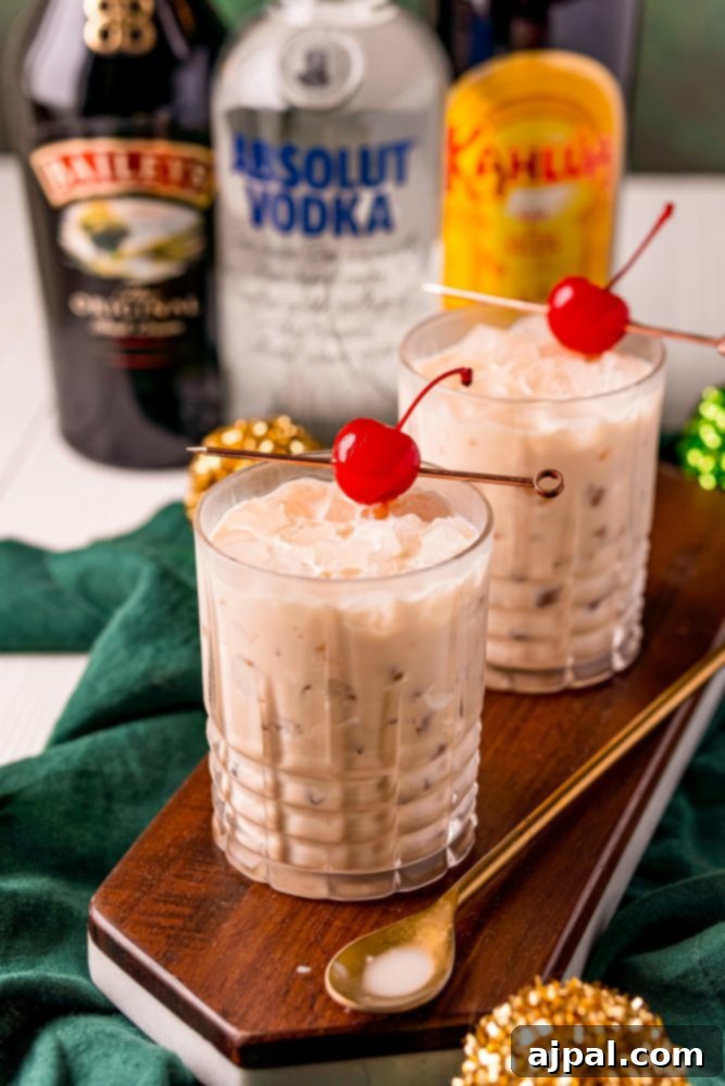Two elegant glasses of Baileys White Russian cocktails, each adorned with a vibrant maraschino cherry, ready to be enjoyed.