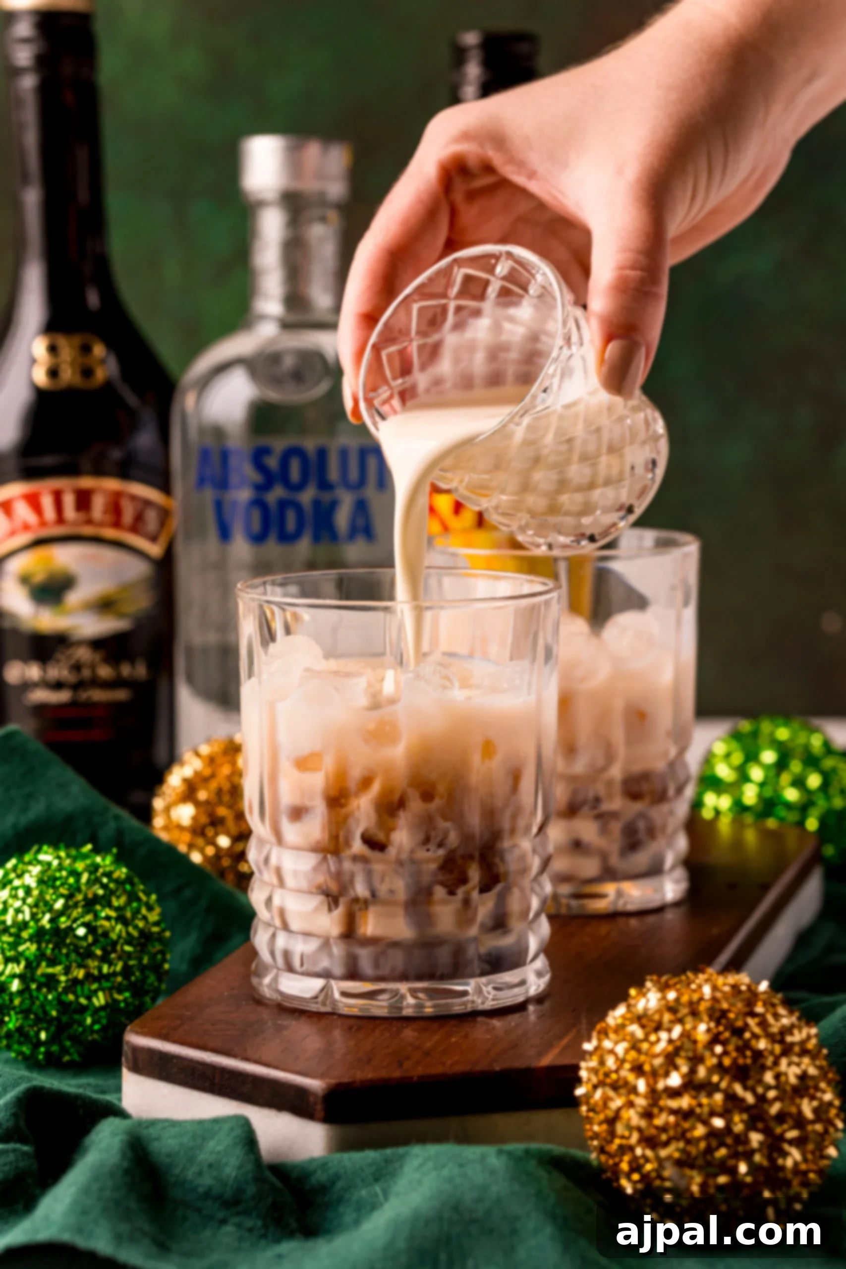 A person meticulously preparing an Irish Cream Kahlua cocktail, combining the rich spirits for a perfect blend.
