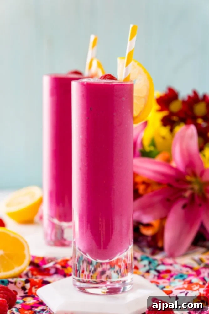 Vibrant Beet Berry Boost 2 Two glasses of raspberry beet smoothie with a hint of beet, garnished with fresh raspberries.