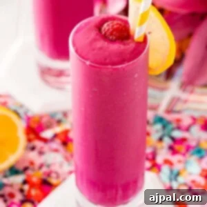 Two glasses of raspberry beet smoothie with a slice of lemon.