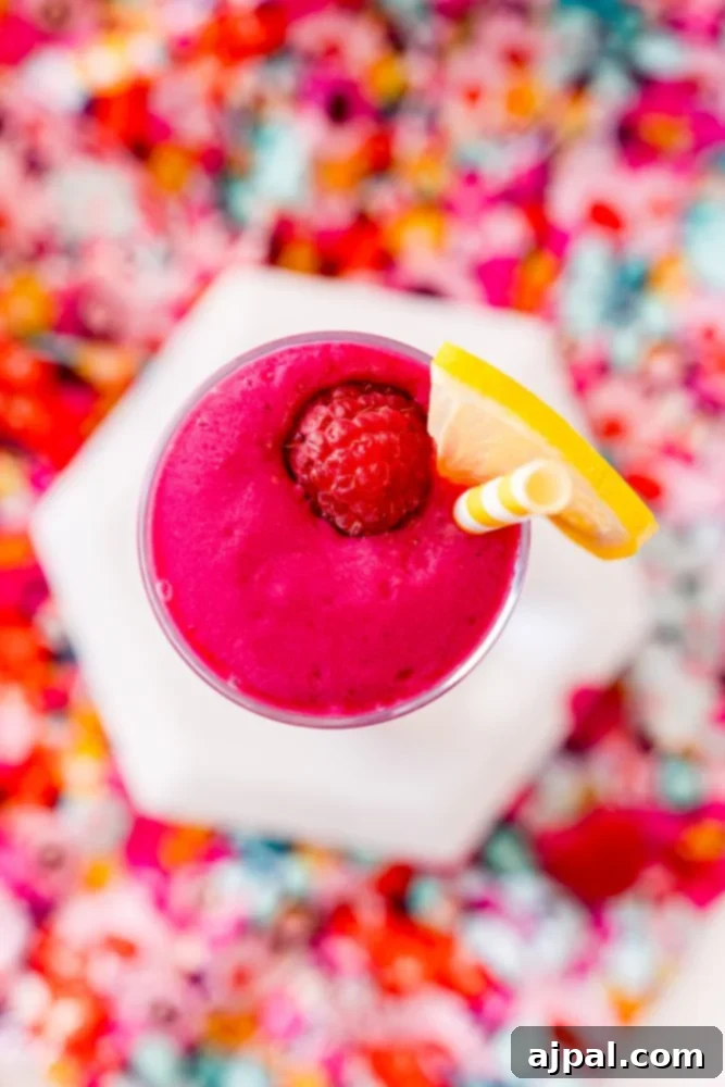 Vibrant Beet Berry Boost 6 A beautiful pink smoothie topped with fresh raspberries, ready to be enjoyed.