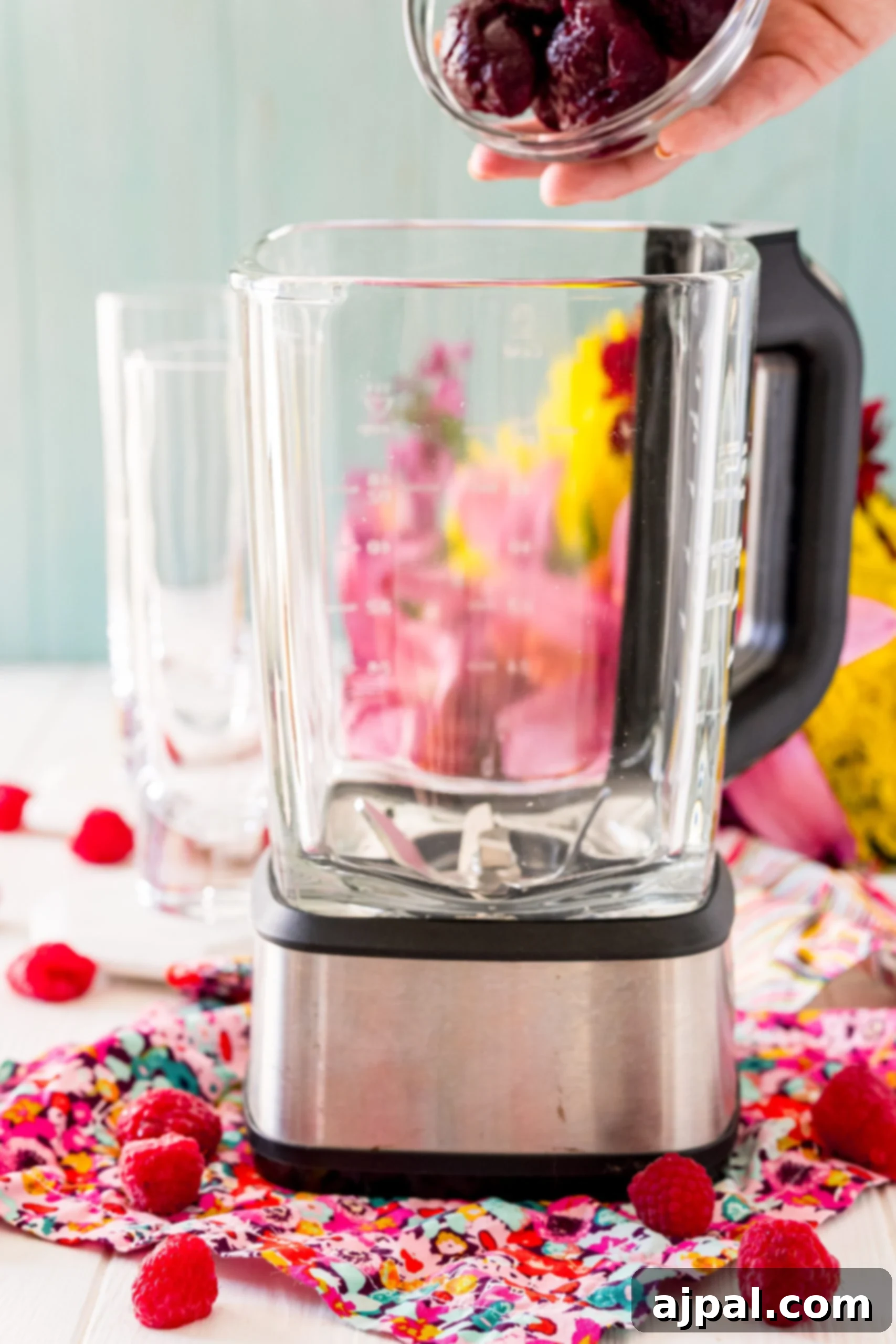 Vibrant Beet Raspberry Blend 7 A person adding raspberries and cottage cheese to a blender for a beet smoothie.