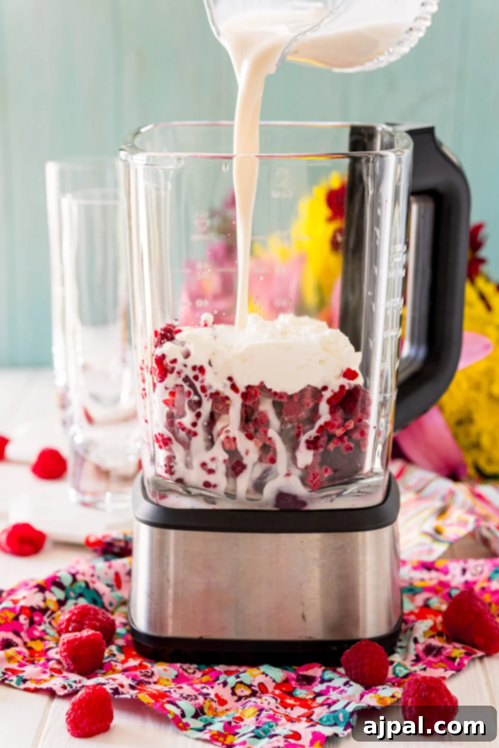 Vibrant Beet Berry Boost 10 A blender with a creamy raspberry beet smoothie, topped with whipped cream and raspberries.