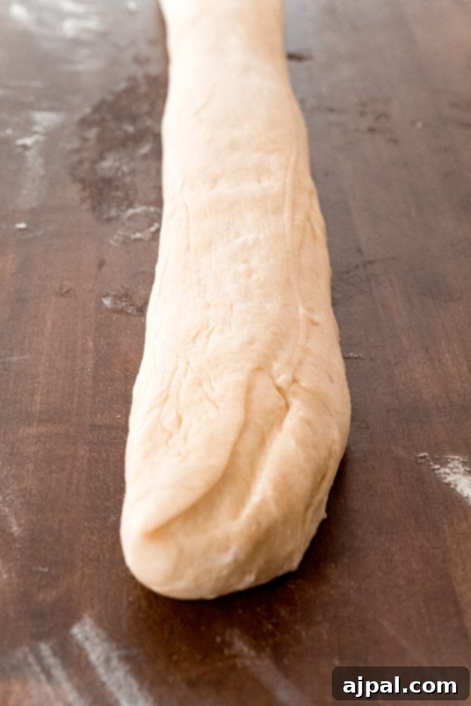 Effortless Melt-in-Your-Mouth Buttery Dinner Rolls 12 picture of roll dough folded over onto table