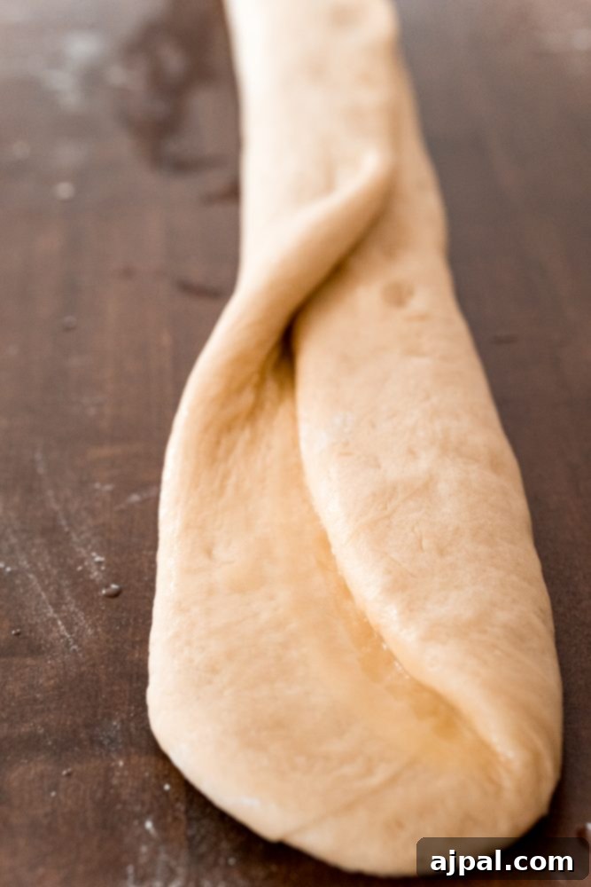 Effortless Melt-in-Your-Mouth Buttery Dinner Rolls 15 picture of bread roll being folded on table