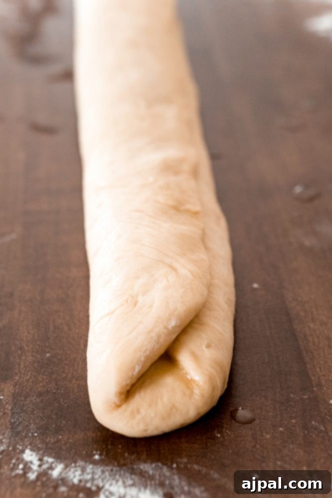 Effortless Melt-in-Your-Mouth Buttery Dinner Rolls 16 picture of bread roll being folded again on table