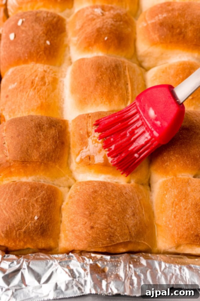 Effortless Melt-in-Your-Mouth Buttery Dinner Rolls 21 picture of pastry brush brushing butter on dinner rolls