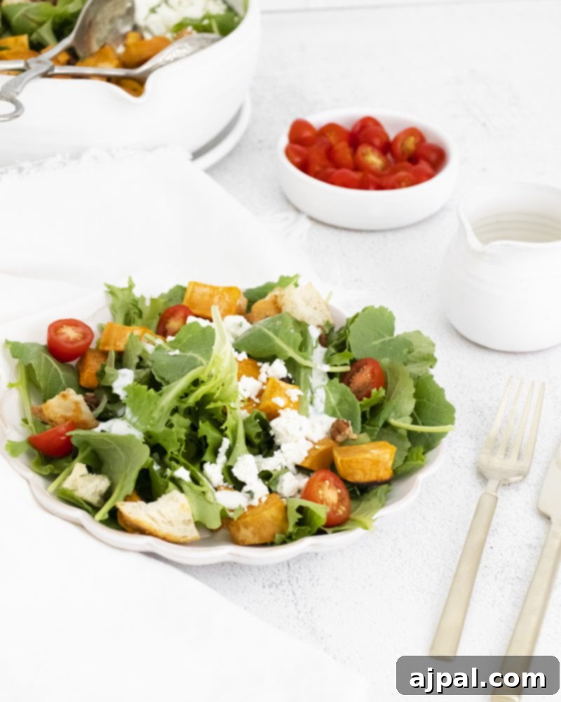 Roasted Sweet Potato Salad with Tangy Goat Cheese 3 A pristine white plate holding a generous portion of Sweet Potato and Goat Cheese Salad, garnished exquisitely.