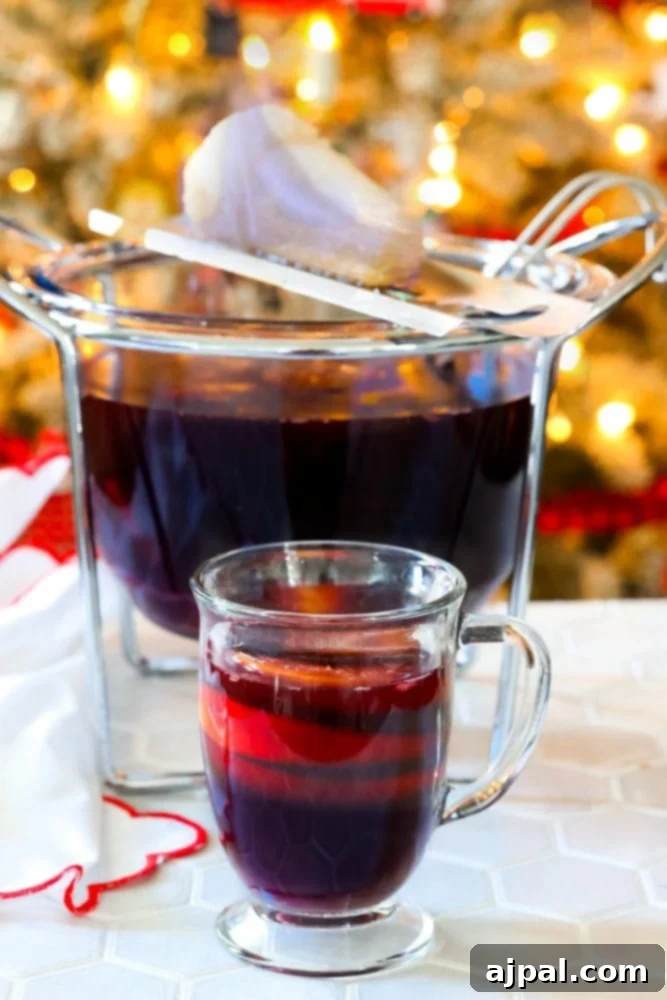 mug with rum punch in front of flaming punch bowl and sugar on fire on top of it