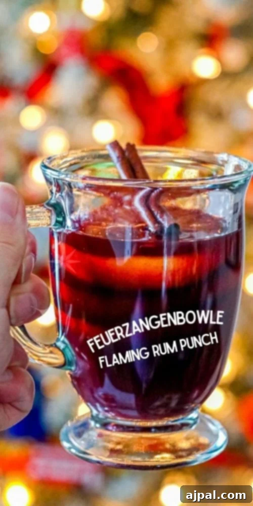 mug with rum punch in front of flaming punch bowl and sugar on fire on top of it