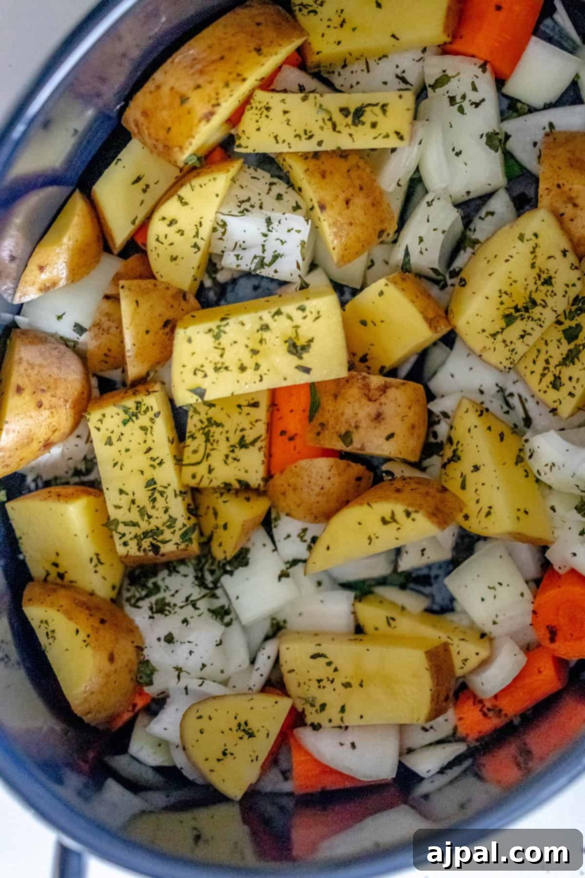 Fall-Apart Tender Instant Pot Pot Roast 5 Chopped potatoes, carrots, onions, and herbs nestled in a pot, ready to create a hearty and flavorful pot roast.