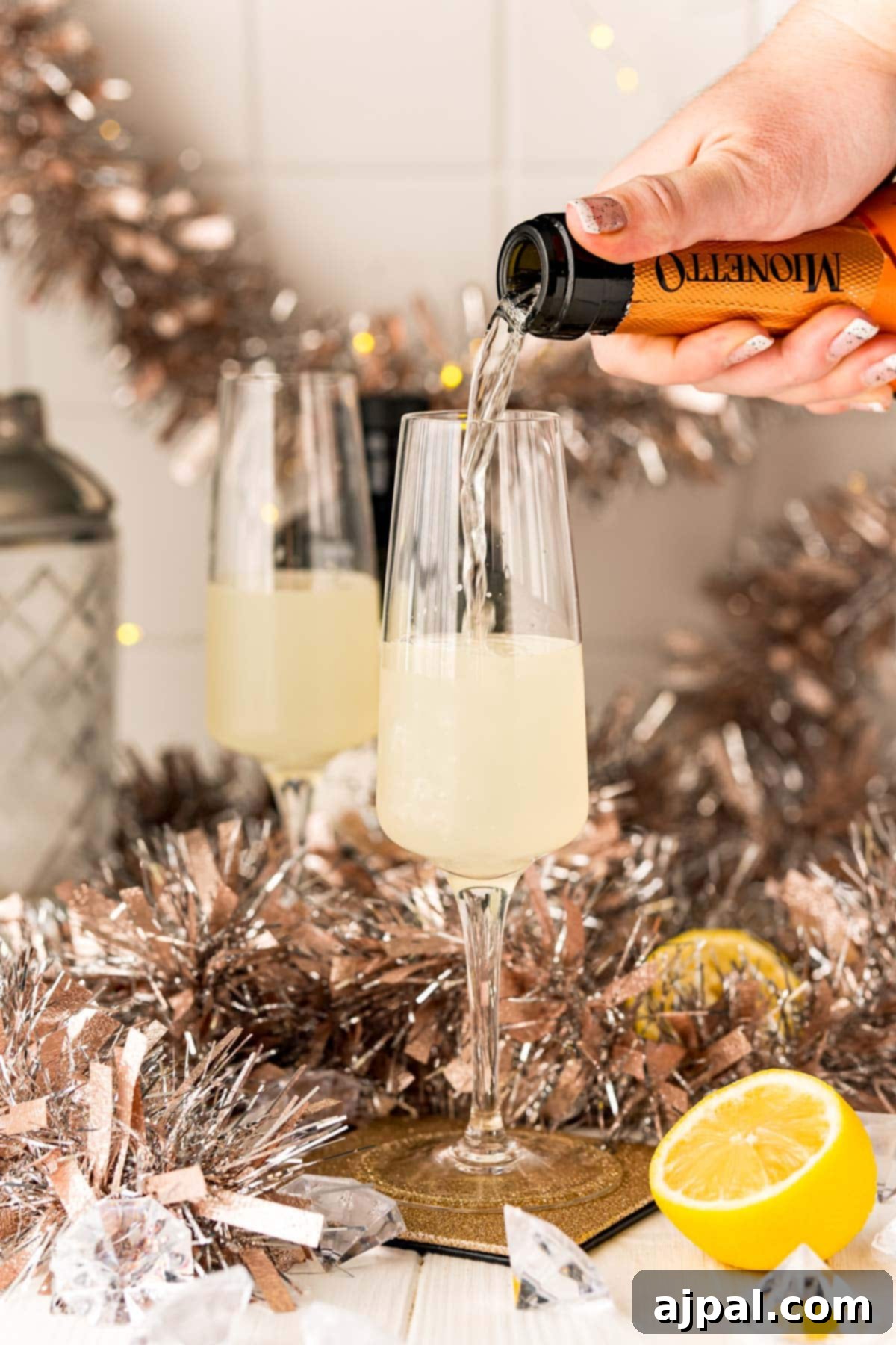 Effortless Champagne Fizz 9 A person mixing gin and champagne to create an Easy Champagne Gin Fizz Cocktail.