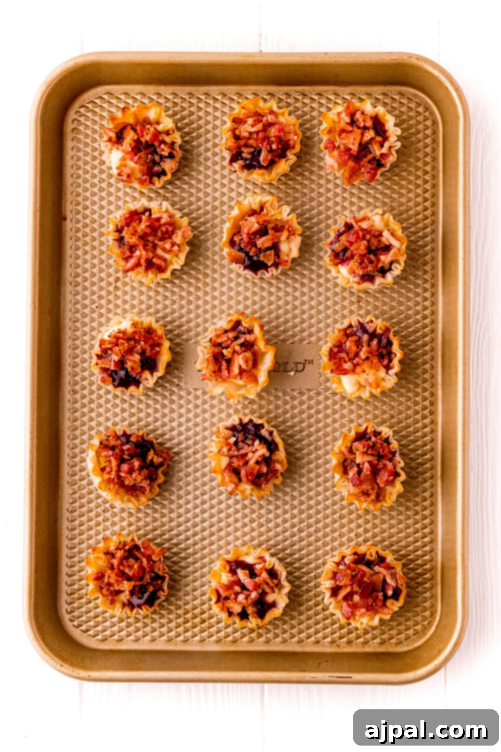 Cheesy Bacon Raspberry Morsels 11 A baking sheet generously filled with small, delightful bites featuring bacon and a raspberry cheese blend, perfect for serving.