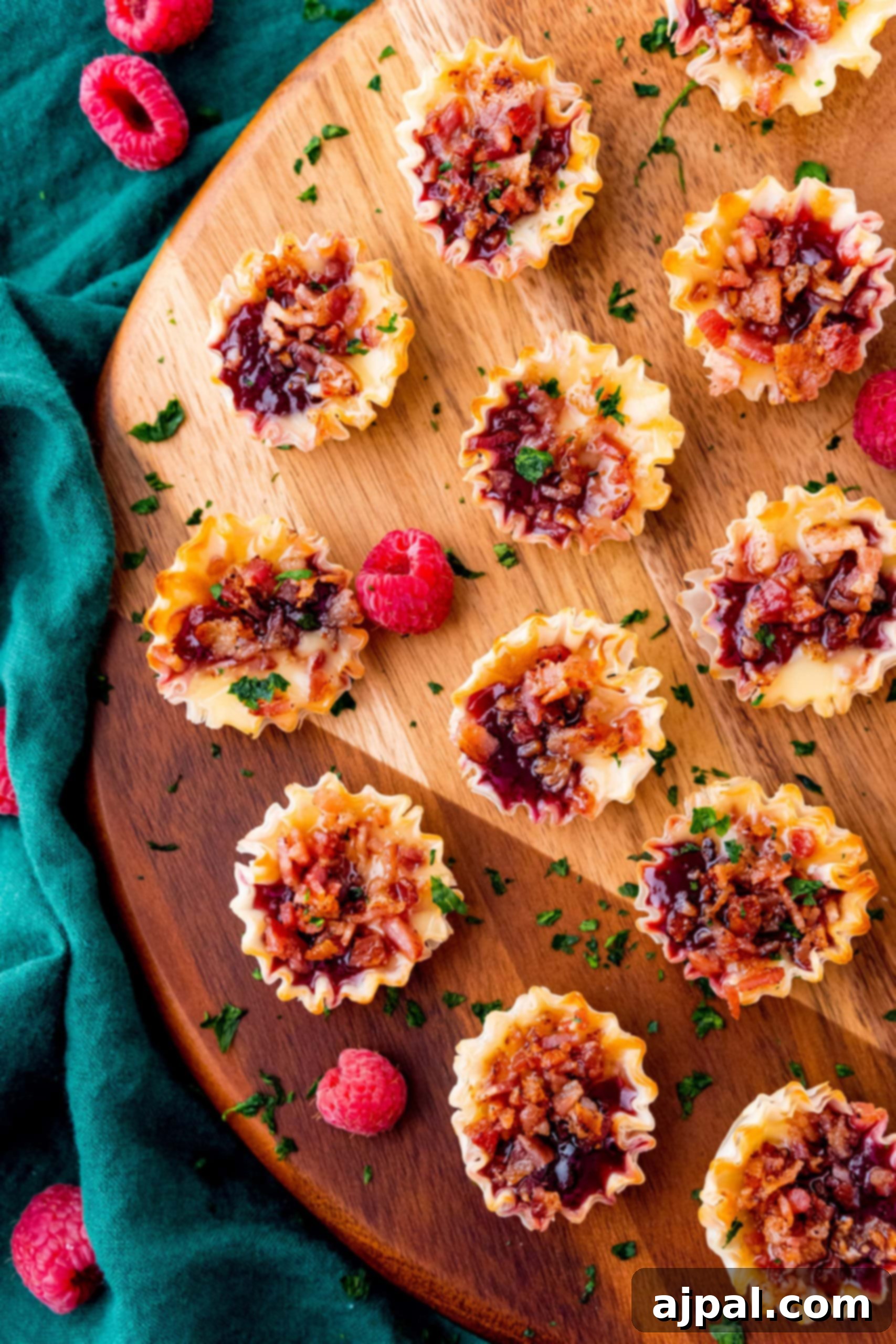 Cheesy Bacon Raspberry Morsels 4 Raspberry bacon bites artfully arranged on a rustic wooden cutting board, showcasing their vibrant colors and crispy textures.