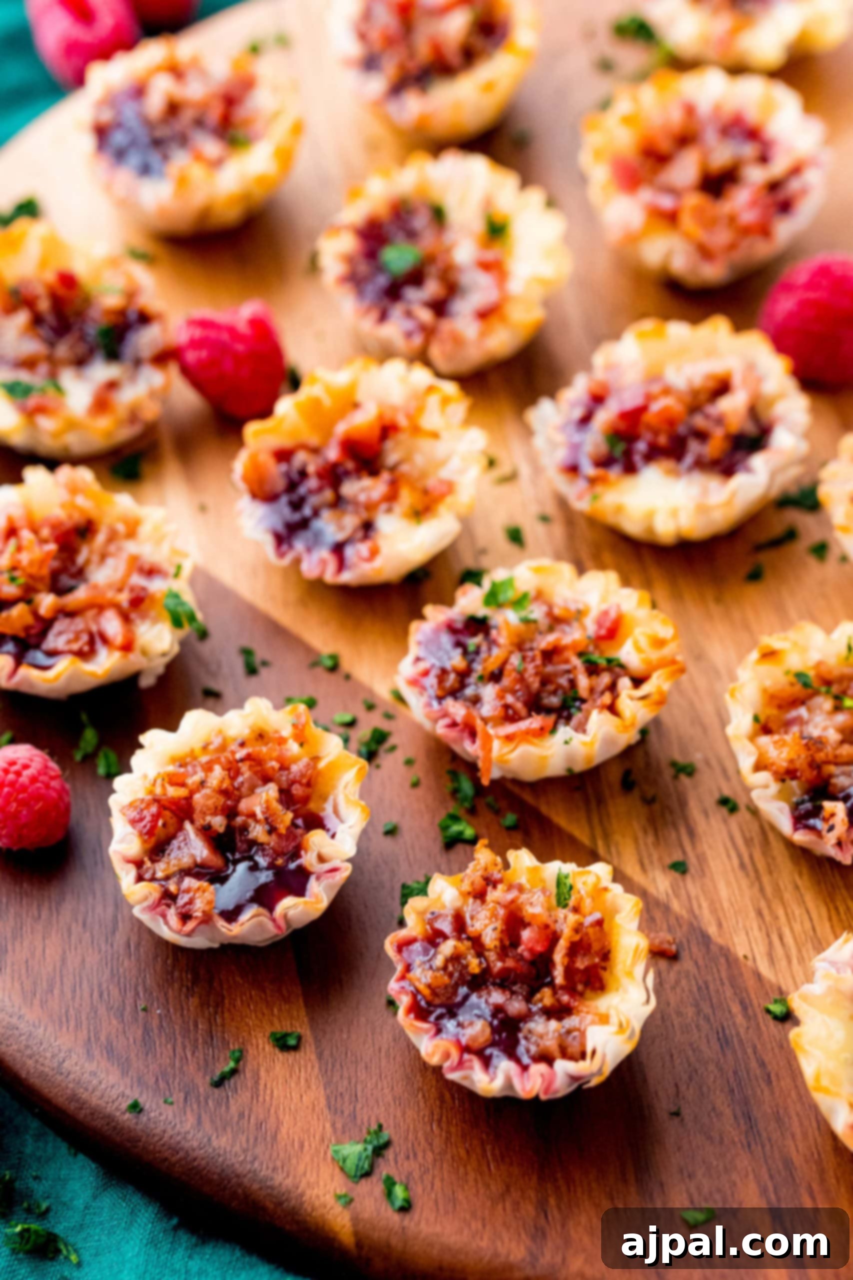 Cheesy Bacon Raspberry Morsels 6 Sweet and savory raspberry and bacon bites displayed on a wooden cutting board, ideal for appetizers.