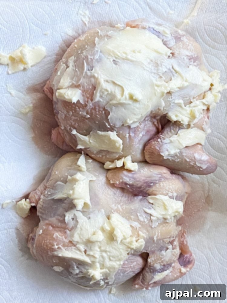 Golden Crispy Air Fryer Cornish Hen 6 Raw Cornish game hens being rubbed with softened butter, ready for seasoning.