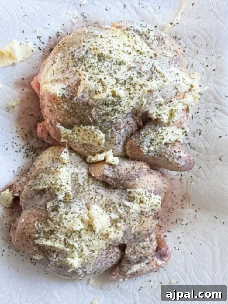 Golden Crispy Air Fryer Cornish Hen 7 Raw Cornish game hens on a plate, generously coated with butter and various seasonings.