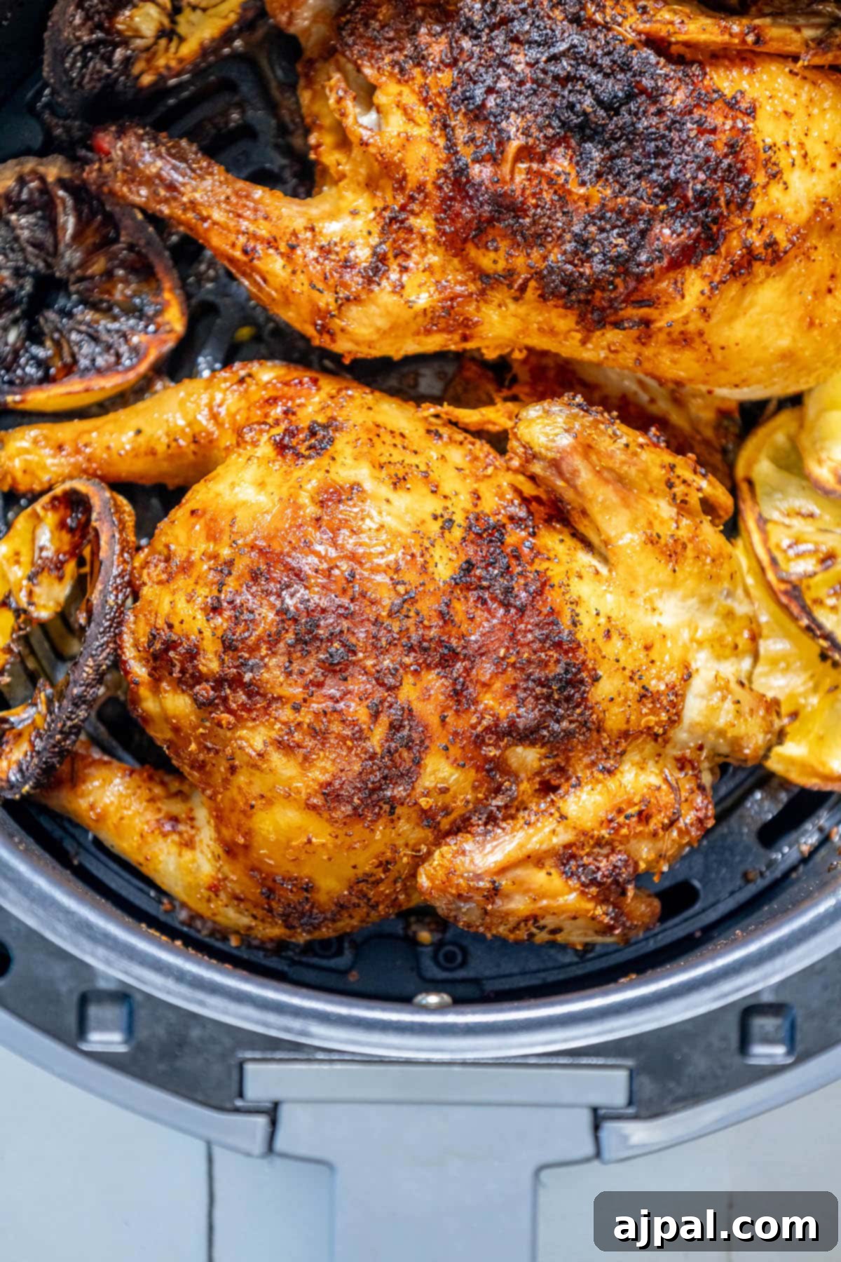 Golden Crispy Air Fryer Cornish Hen 10 Succulent air-fried Cornish game hens, beautifully seasoned with fresh herbs, nestled in an air fryer basket, showcasing their golden-brown crispiness.