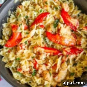 Delectable bowtie pasta in a pan with herbs, cheese, and tender lobster meat.