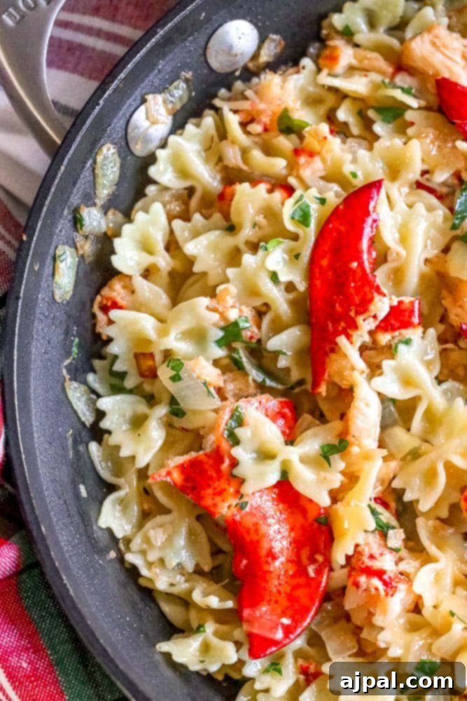 Effortless Lobster Pasta Delight 3 bowtie pasta in a pan with herbs, cheese, sauteed onions, and lobster meat