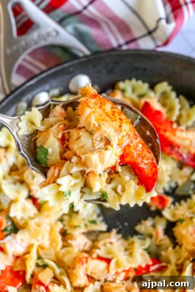 A serving spoon lifting delicious lobster meat pasta from a pan, showcasing the rich sauce, herbs, and cheese amidst bowtie pasta.