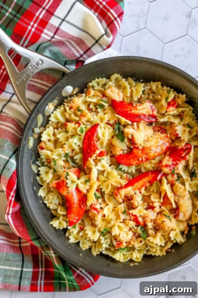 Exquisite lobster pasta, prepared with garlic and vibrant red peppers, served in a skillet.
