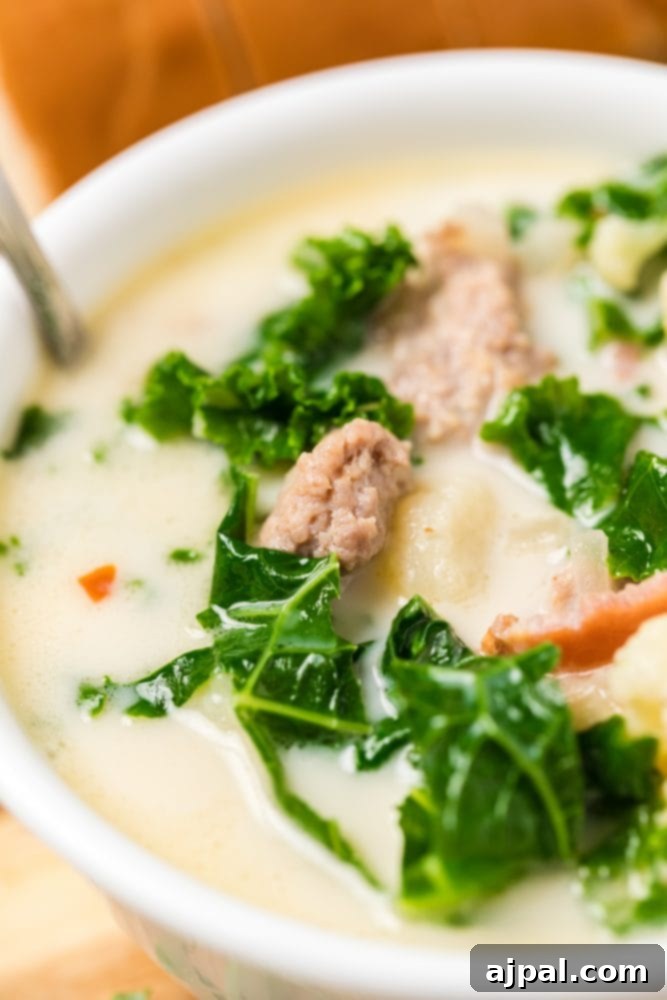 Simple Creamy Keto Tuscan Kale Soup 2 A bowl of steaming Keto Tuscan Kale Soup with sausage, kale, and roasted cauliflower, garnished with fresh herbs.