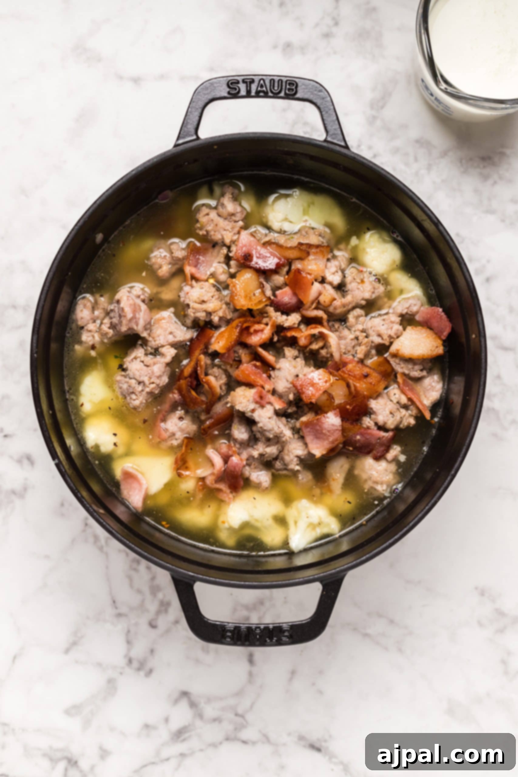 Simple Creamy Keto Tuscan Kale Soup 11 A close-up of a delectable bowl of Easy Keto Tuscan Kale Soup, featuring meat and crispy bacon bits.