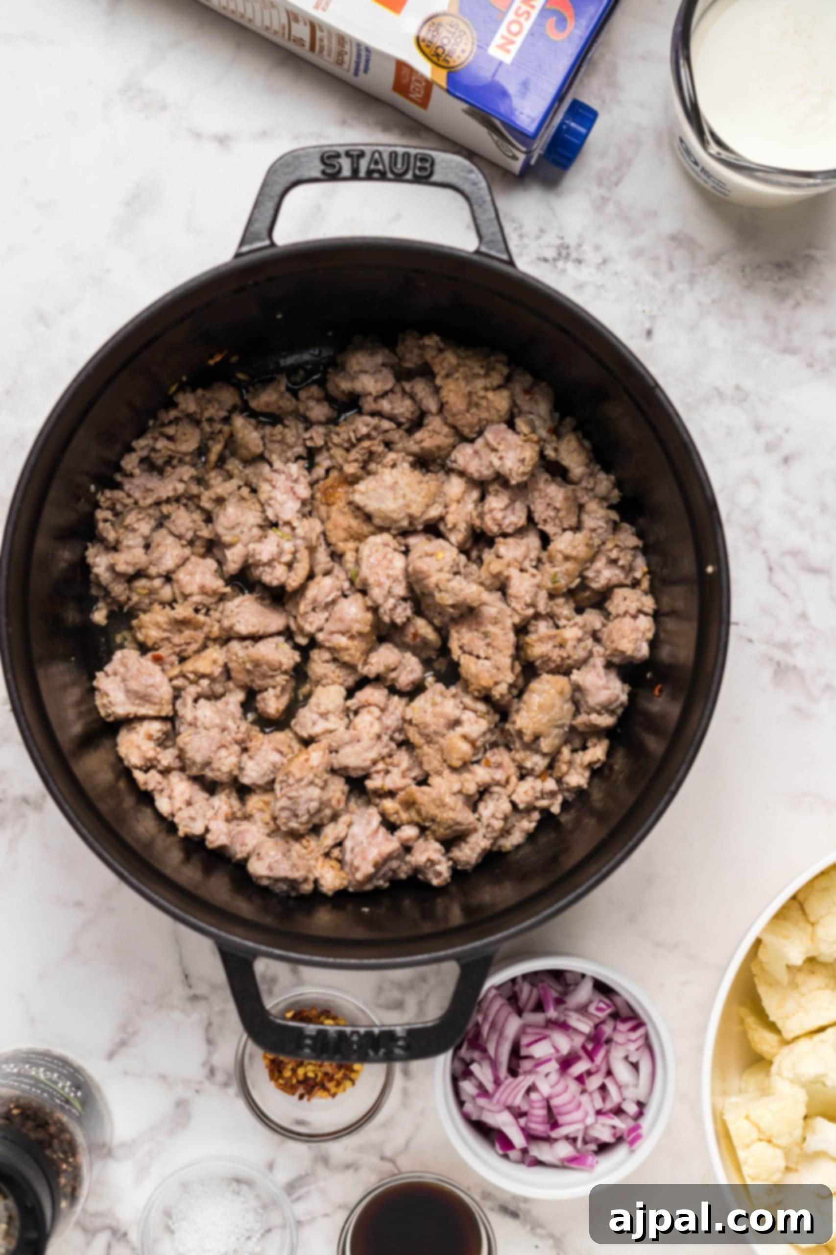 Simple Creamy Keto Tuscan Kale Soup 10 A skillet filled with a rich, simmering Keto Zuppa Toscana, showcasing the hearty sausage, kale, and creamy broth.