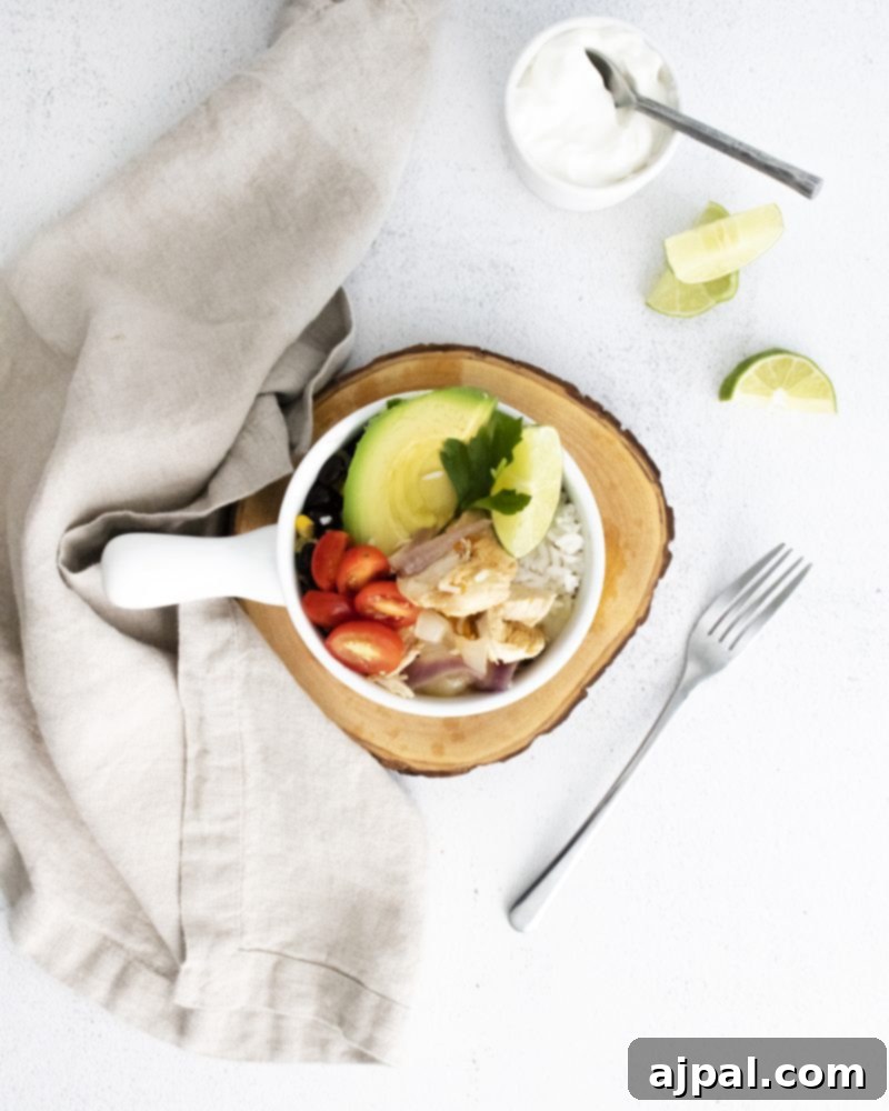 A rustic wooden table displaying a bowl of freshly made guacamole alongside a plate of sliced avocados, ready to accompany a delicious easy chicken fajita recipe.