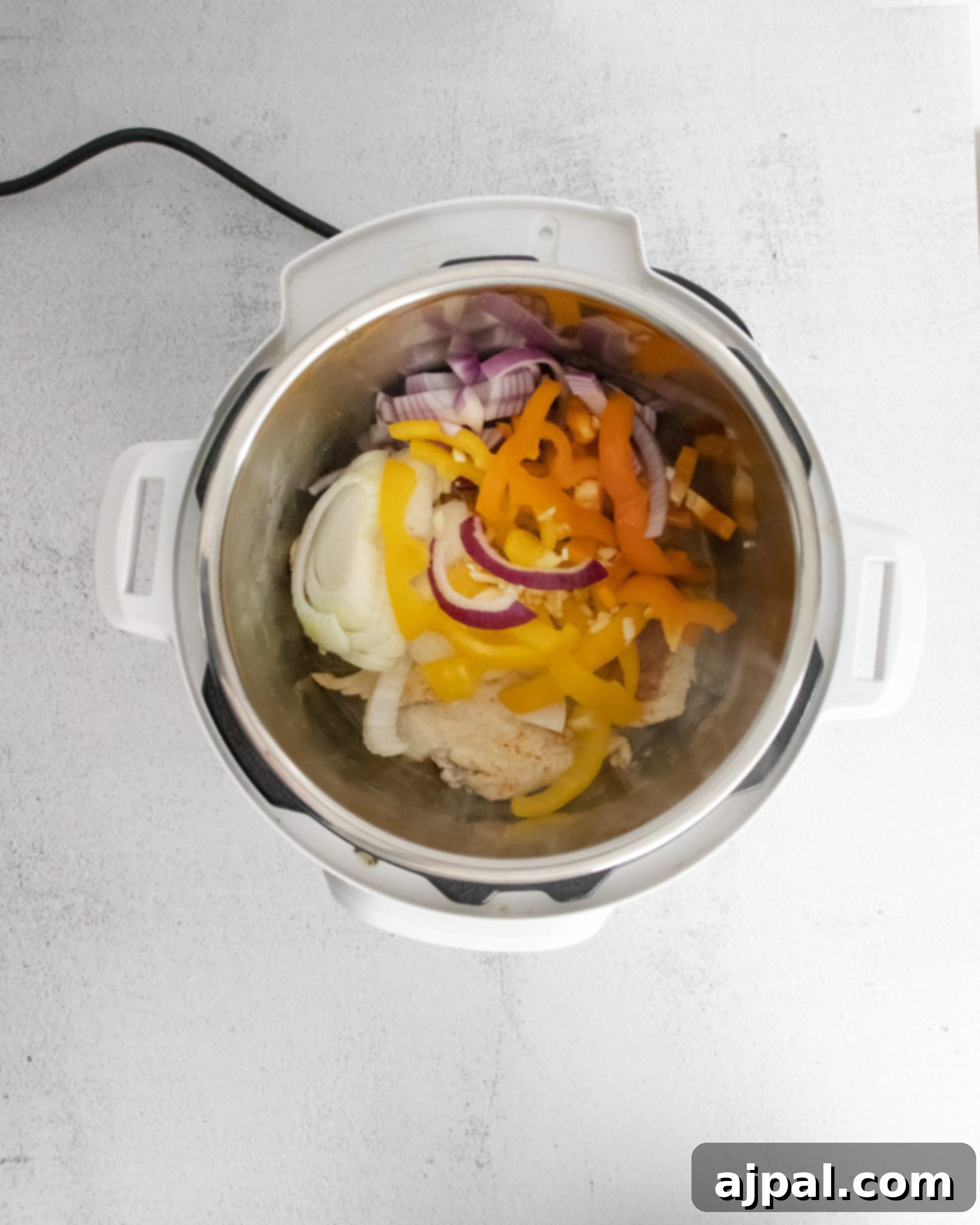 An Instant Pot filled with a colorful medley of tender vegetables and seasoned chicken, ready to transform into delicious fajita bowls.