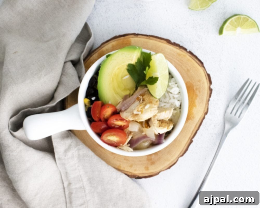 A vibrant Instant Pot Chicken Fajita Bowl, richly colored with tender chicken, creamy avocado, ripe tomatoes, and zesty limes, promising a flavorful and healthy meal.