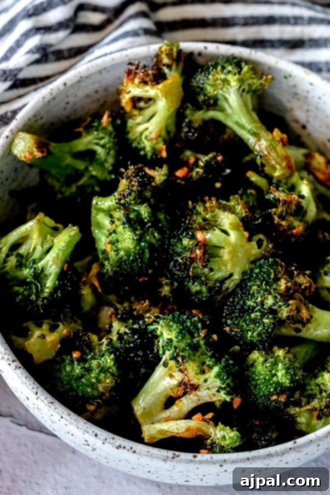Crispy Air Fried Broccoli 2 Deliciously crispy air-fried broccoli seasoned with spicy garlic, presented in a rustic bowl.
